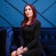 Laura Loomer sits on a blue couch against a blue wall