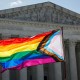 A person waves LGBTQ flag.