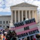 Transgenders rights supporters rally outside of the Supreme Court, a sign is held saying "Trans Rights Are Human Rights"