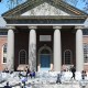 People sitting on the steps of a campus building at Hardvard