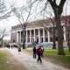 Pedestrians walk past the Widener Library