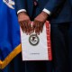 Damian Williams, U.S. attorney for the Southern District of New York, holds a "confidential" binder during a news conference at the Department of Justice in Washington.