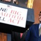 Mike Johnson, right, next to a podium with a sign that reads "One Big Beautiful Bill Act"