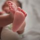 Close up of mixed race newborn baby girl's feet