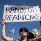 Brenda Patoine holds a sign that reads "Hands off Healthcare"