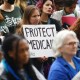 A woman holds a sign that reads "Protect Medicaid"