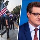 A split composite image of a man walking across a street holding an American flag with police standing behind him, left, and Chris Hayes