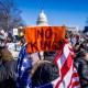 Demonstrators hold signs during the No Kings Day.