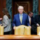 Mitch McConnell stands next to his chair.