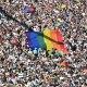 Crowd holding a Pride flag during the parade.
