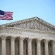 The Supreme Court building with the American flag waving in front of it