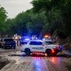 Police cars and officials on a muddy road