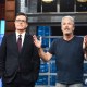 Stephen Colbert, left, and Jon Stewart stand next to each other on stage as Jon speaks