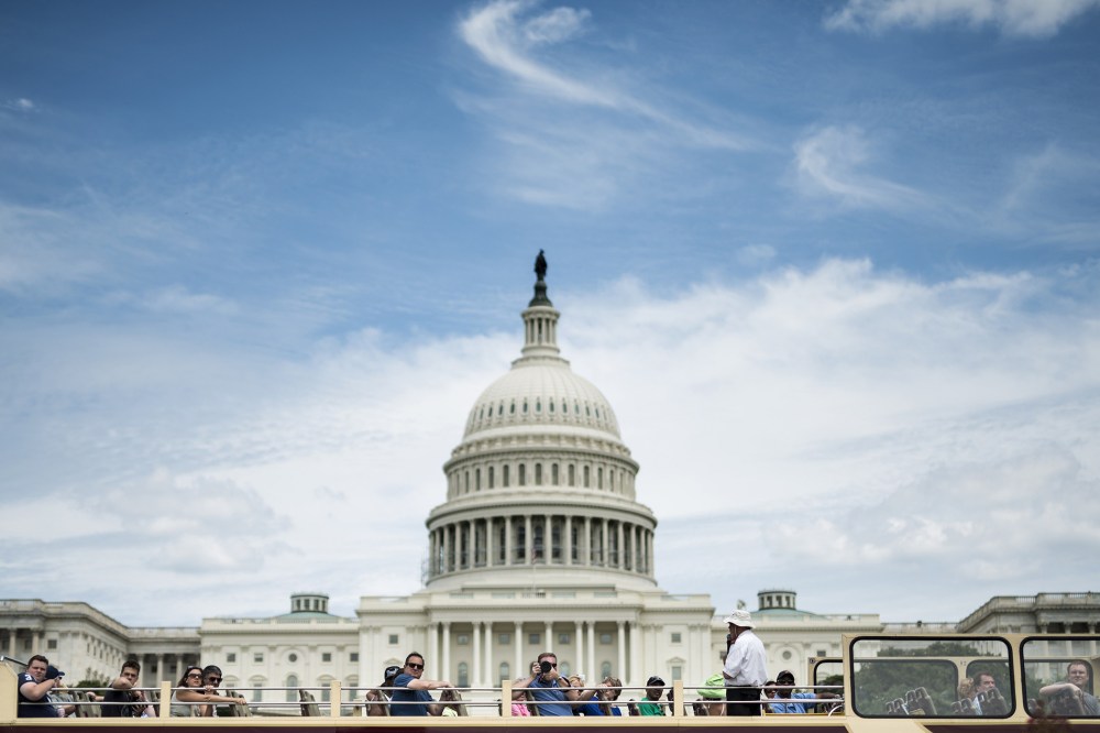 Tourists pass the US Capitol building on a bus, July 19, 2014 in Washington, DC.