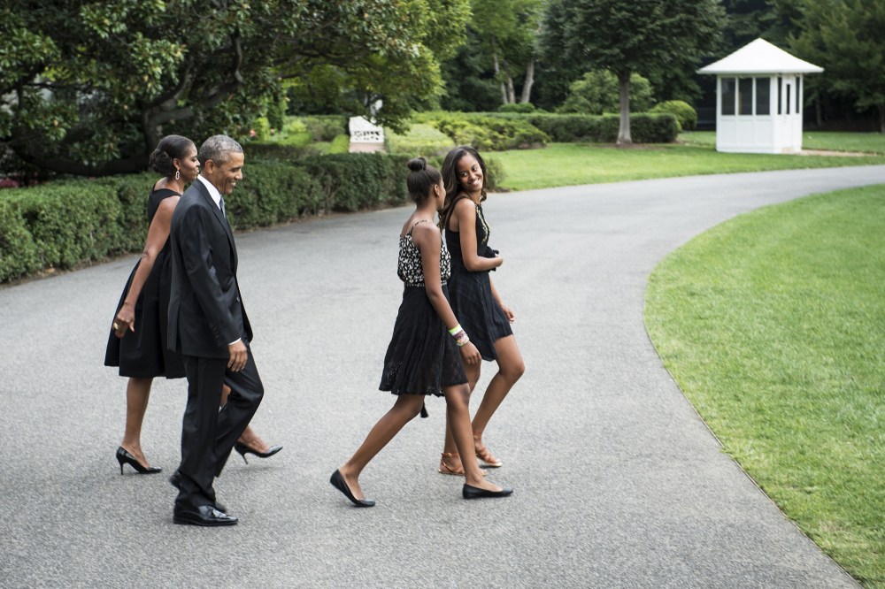 US President Barack Obama (2L) and US First Lady Michelle Obama (L) catch up to their daughters Sasha (2R) and Malia while walking to Marine One on the South Lawn of the White House on Aug. 30, 2014 in Washington, DC.