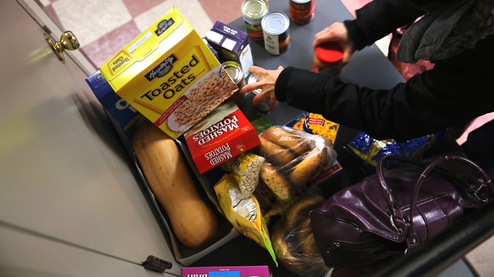 People receive free groceries at a food pantry run by the Food Bank For New York City on Dec. 11, 2013 in New York City.