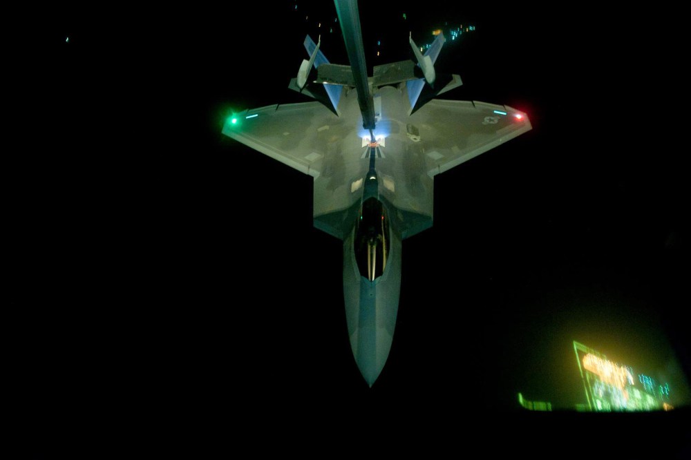 In this handout image provided by the U.S. Air Force, A KC-10 Extender refuels an F-22 Raptor fighter aircraft prior to strike operations in Syria, during flight on Sept. 26, 2014. (Photo by Tech. Sgt. Russ Scalf/U.S. Air Force /Getty)