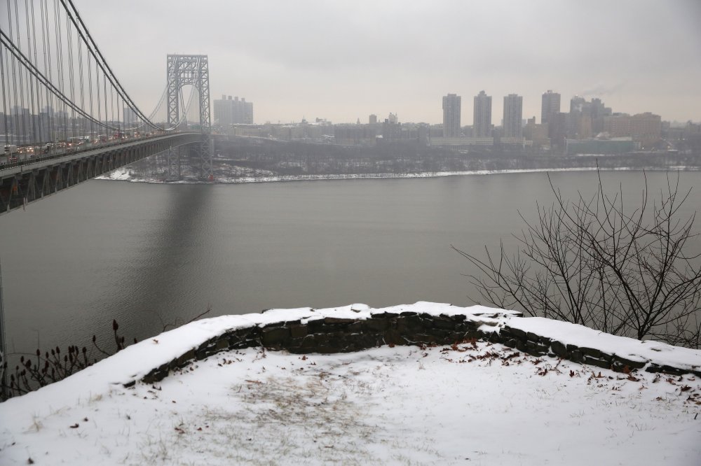Snow covers the Palisades Interstate Park overlooking the George Washington Bridge between New York City (R), and Fort Lee, New Jersey on December 17, 2013.