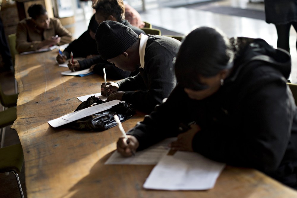 Job seekers fill out paperwork during a Virgin Hotels job fair in Chicago, Ill. on Nov. 5, 2014. (Photo by Daniel Acker/Bloomberg/Getty)
