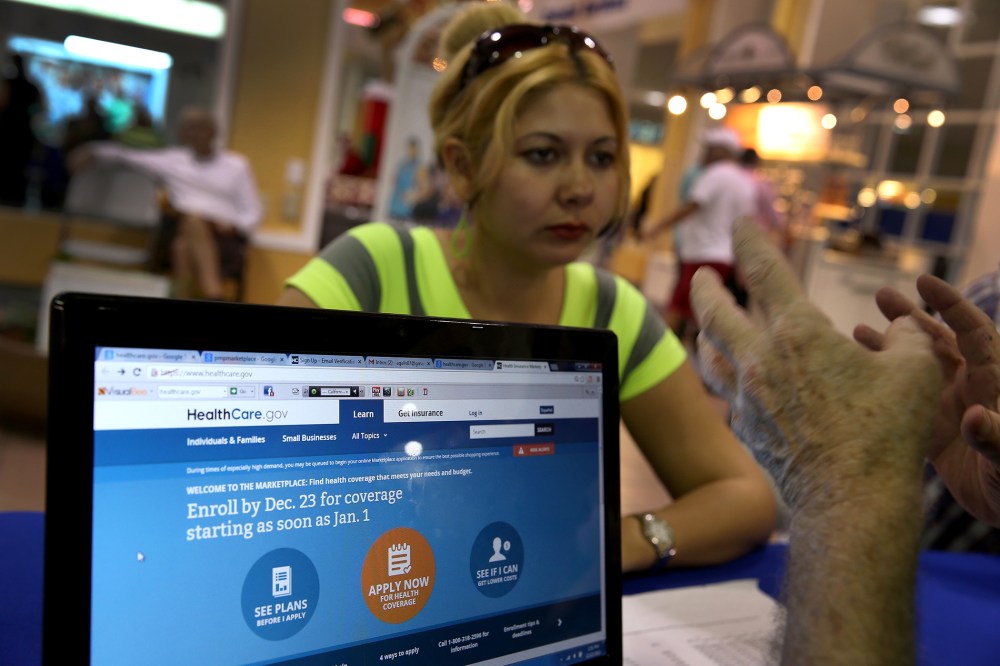 Rocelys Corrales of Miami sits with an insurance agent from Sunshine Life and Health Advisors as she inquires about purchasing health insurance, Dec. 22, 2013.