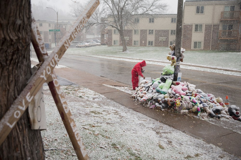 Chris Seltzer cleans the area around a memorial near the location where 18-year-old Michael Brown was shot, Nov. 16, 2014 in Ferguson, Mo. (Scott Olson/Getty)