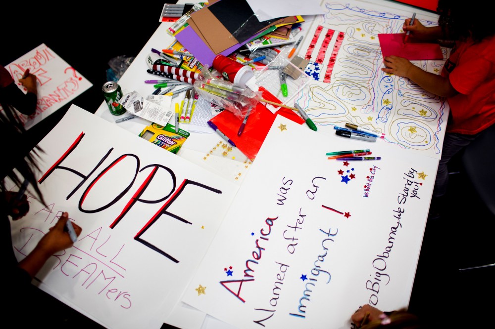 Attendees make signs at the offices of 32BJ SEIU, a workers union, during a viewing party for U.S. President Barack Obama's speech on evecutive action immigration policy reform on Nov. 20, 2014 in New York City. (Photo by Kevin Hagen/Getty)