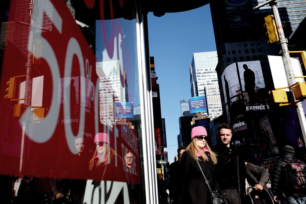 People walk past a store displaying a discount sign in Times Square in New York on Nov. 21, 2014. The National Retail Federation said last month it expects overall holiday sales this year to rise to $616.9 billion, a 4.1 percent increase from last year's