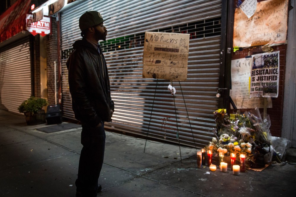 A man pauses at an makeshift memorial for Eric Garner, the man killed by a police officer in July using a chokehold, outside the beauty salon where the confrontation took place, on Dec, 3, 2014 in Staten Island. (Andrew Burton/Getty)