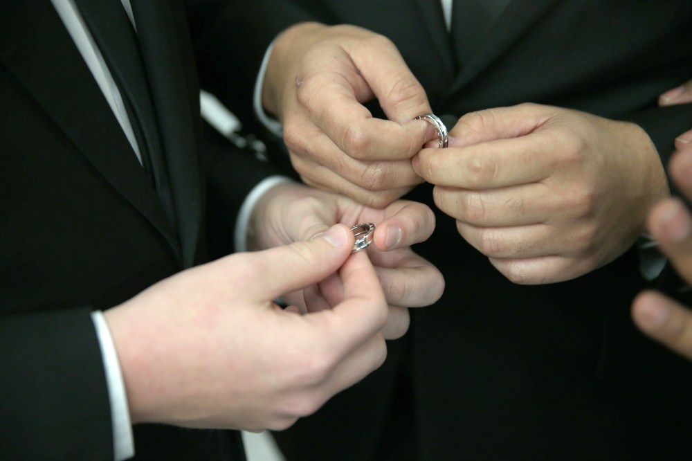 A couple exchange rings as they are wed during a wedding ceremony. (Photo by Joe Raedle/Getty)