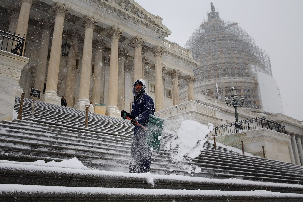 Clearing a path for Congress, an employee of the Architect of the Capitol shovel snow off the steps of the U.S. House of Representatives as more snow continues to fall on Jan. 6, 2015 in Washington, DC. (Photo by Chip Somodevilla/Getty)