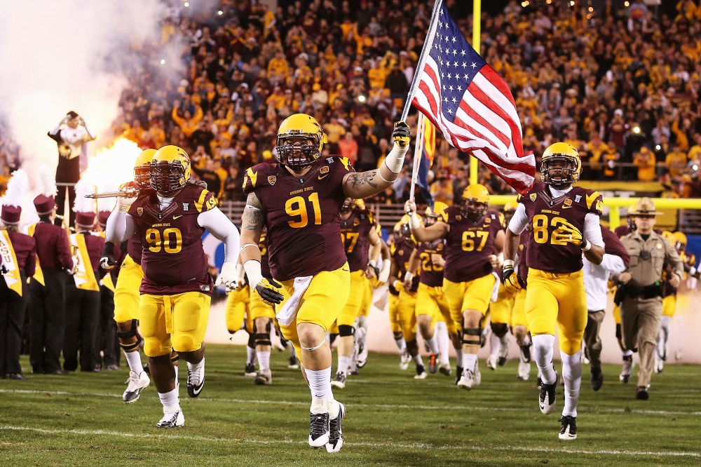 Arizona State Sun Devils players run out onto the field before a game against the Stanford Cardinals at Sun Devil Stadium on December 7, 2013.