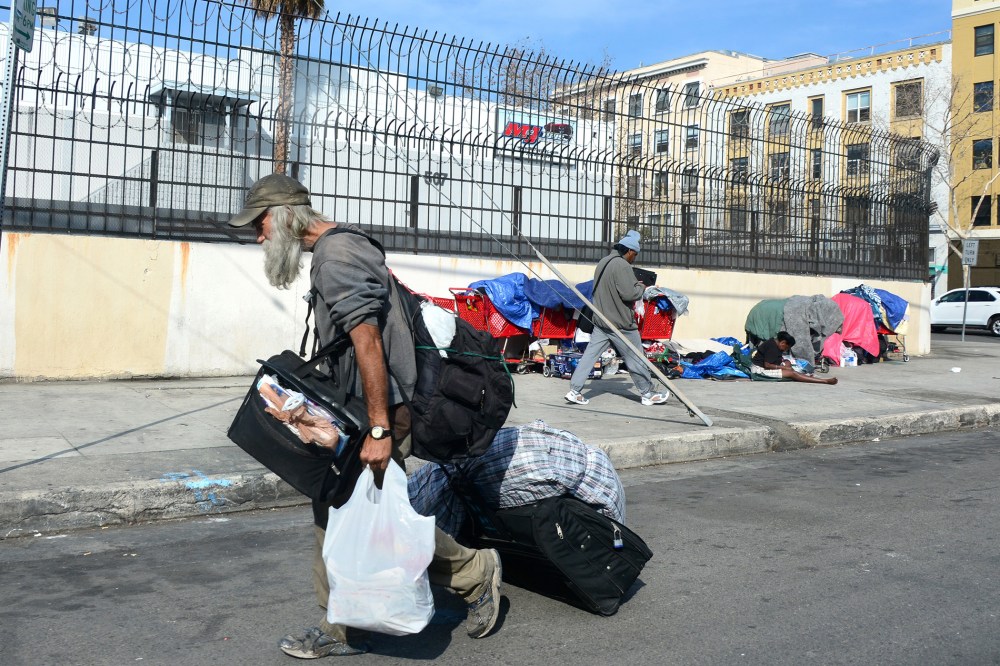A homeless man carries his belongings in downtown Los Angeles, California, on January 8, 2014.