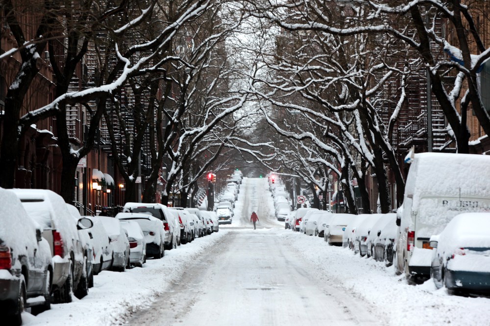 A passerby walks through an accumulation of snow on Jan. 27, 2015 on the Upper East Side of New York. (Photo by Yana Paskova/Getty)