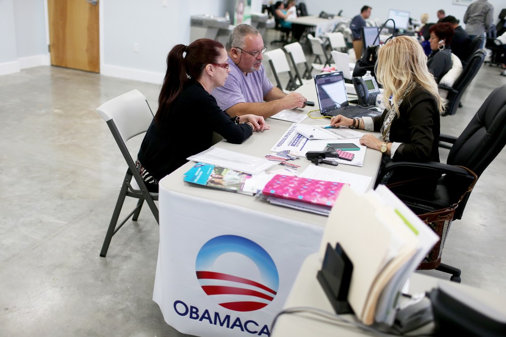 Aymara Marchante and Wiktor Garcia sit with UniVista insurance advisor Maria Elena Santa Coloma as they sign up for the Affordable Care Act, also known as Obamacare, on Feb. 5, 2015 in Miami, Florida. (Photo by Joe Raedle/Getty)