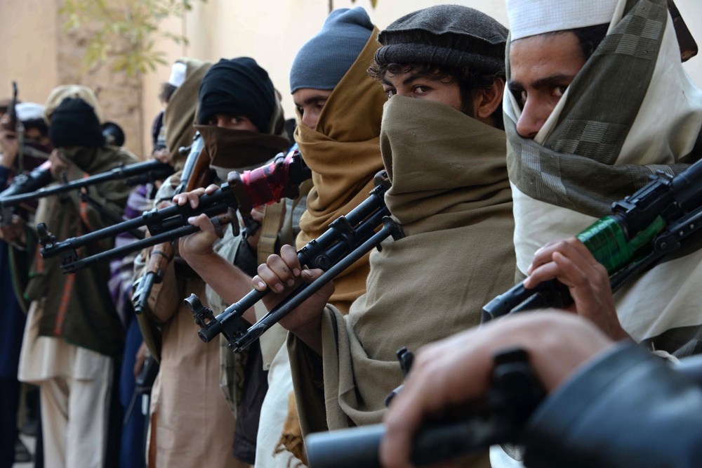 Afghan former Taliban fighters are photographed holding weapons before they hand them over as part of a government peace and reconciliation process at a ceremony in Jalalabad on Feb. 8, 2015. (Photo by Noorullah Shirzada/AFP/Getty)