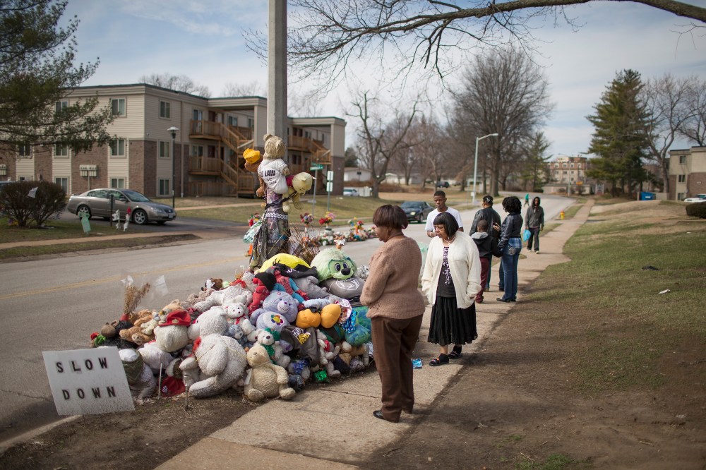 Visitors look over a memorial to Michael Brown outside the Canfield Green apartments where he was shot and killed by a police officer last August on March 14, 2015 in Ferguson, Mo. (Photo by Scott Olson/Getty)