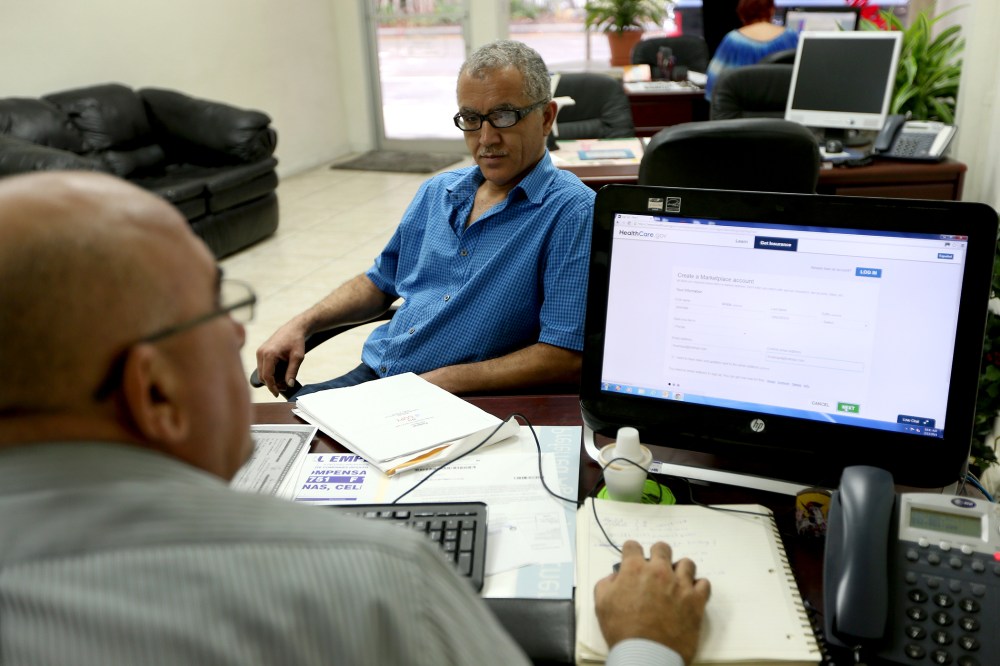 Hisham Uadadeh enrolls in a health insurance plan under the Affordable Care Act with the help of A. Michael Khoury in Miami, Feb. 13, 2014.