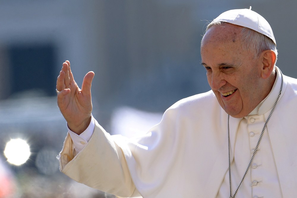 Pope Francis salutes the crowd as he arrives for his weekly general audience in St Peter's square at the Vatican on April 22, 2015. (Photo by Filippo Monteforte/AFP/Getty)