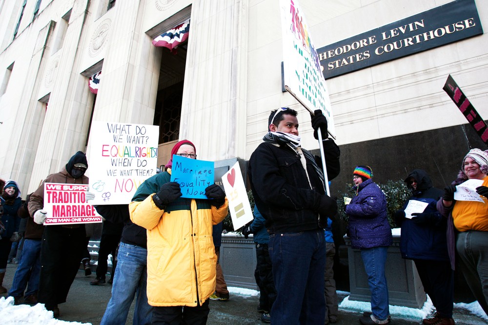 Pro-traditional marriage supporters protest next to gay marriage supporters in front of the U.S. Federal Courthouse in Detroit, Michigan, Mar. 3, 2014.