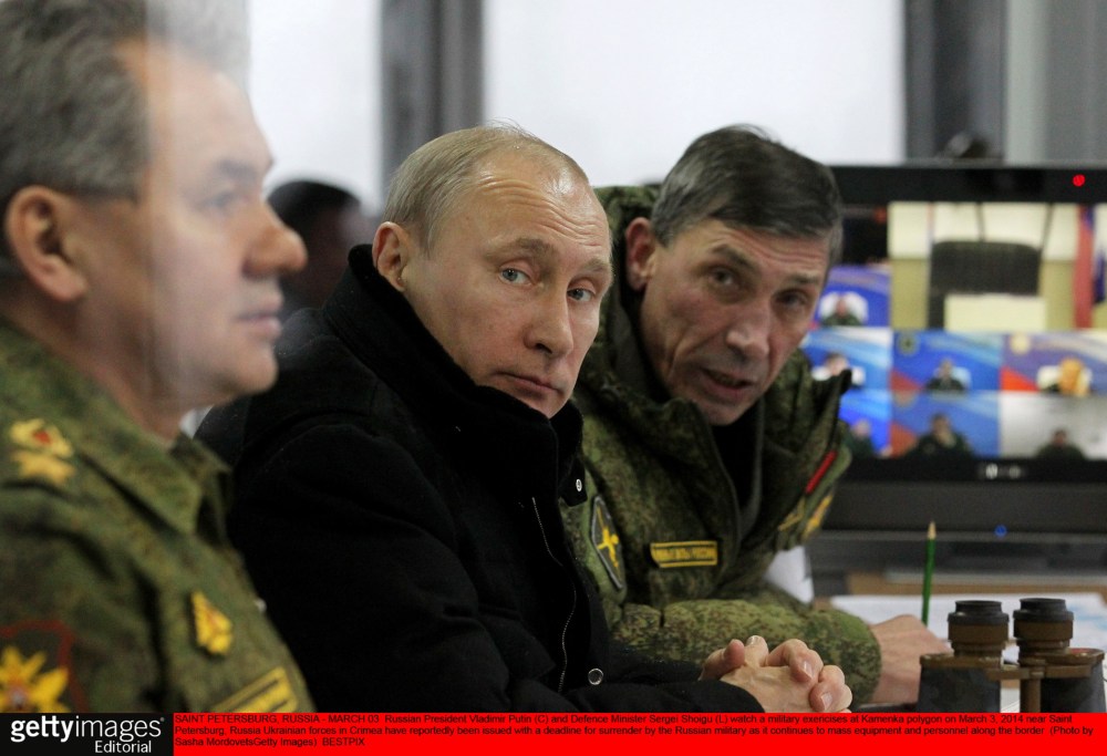 Russian President Vladimir Putin (C) and Defense Minister Sergei Shoigu (L) watch a military exercises at Kamenka polygon on March 3, 2014 near Saint Petersburg, Russia.