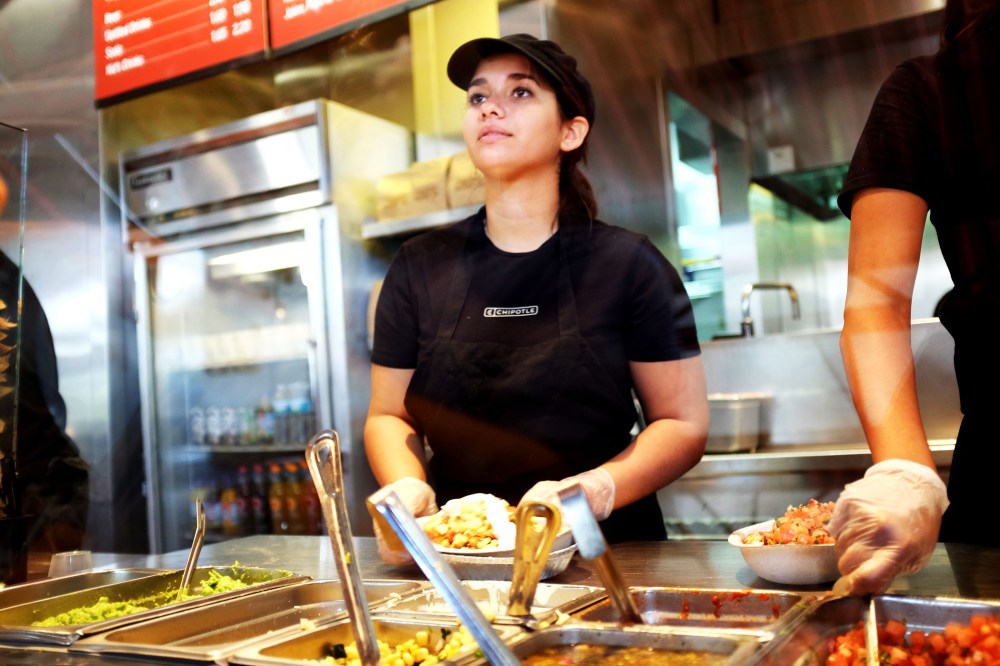 A restaurant worker fills an order at a Chipotle restaurant on March 5, 2014 in Miami, Florida.