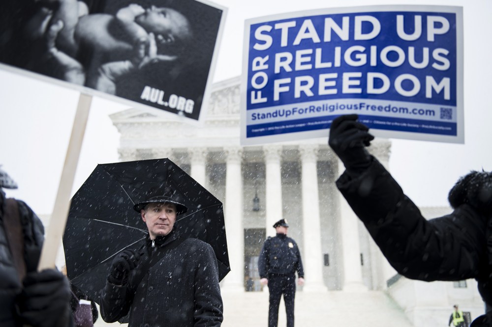 People who support Hobby Lobby's choice to withhold contraceptive healthcare coverage from their employees rally outside the US Supreme Court, Mar. 25, 2014.