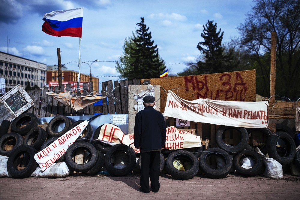 An elderly man stands next a barricade near the secret service building in the eastern Ukrainian city of Lugansk, April 22, 2014.