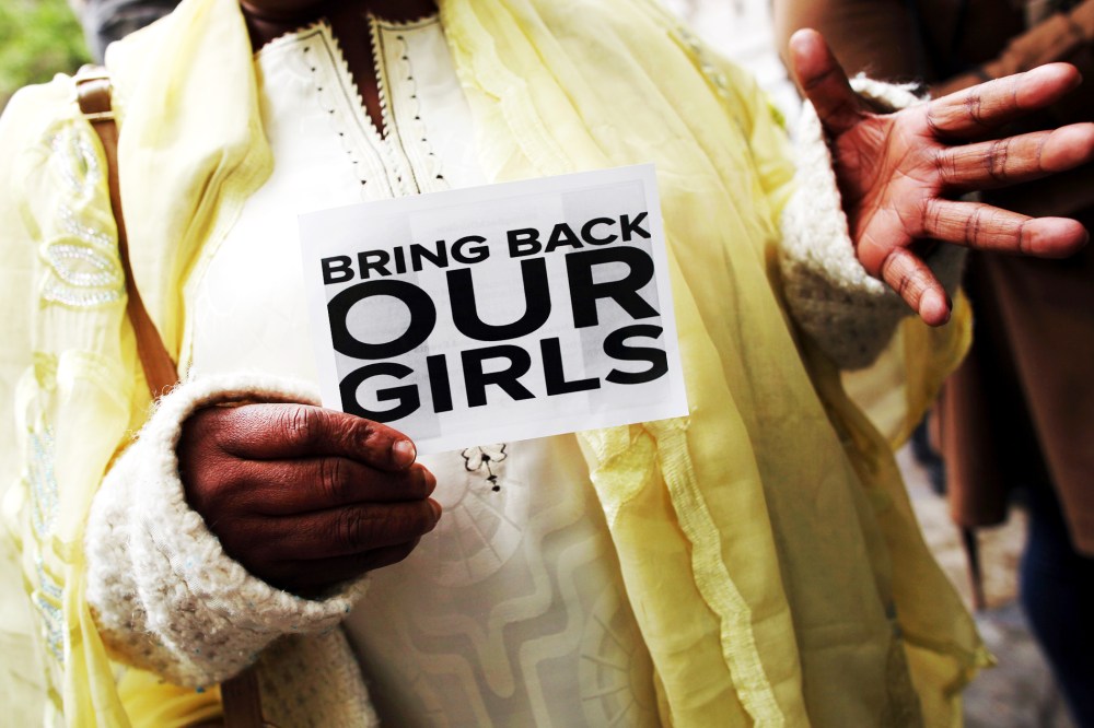 A woman holds a sign that reads 'Bring back our girls' during a protest.