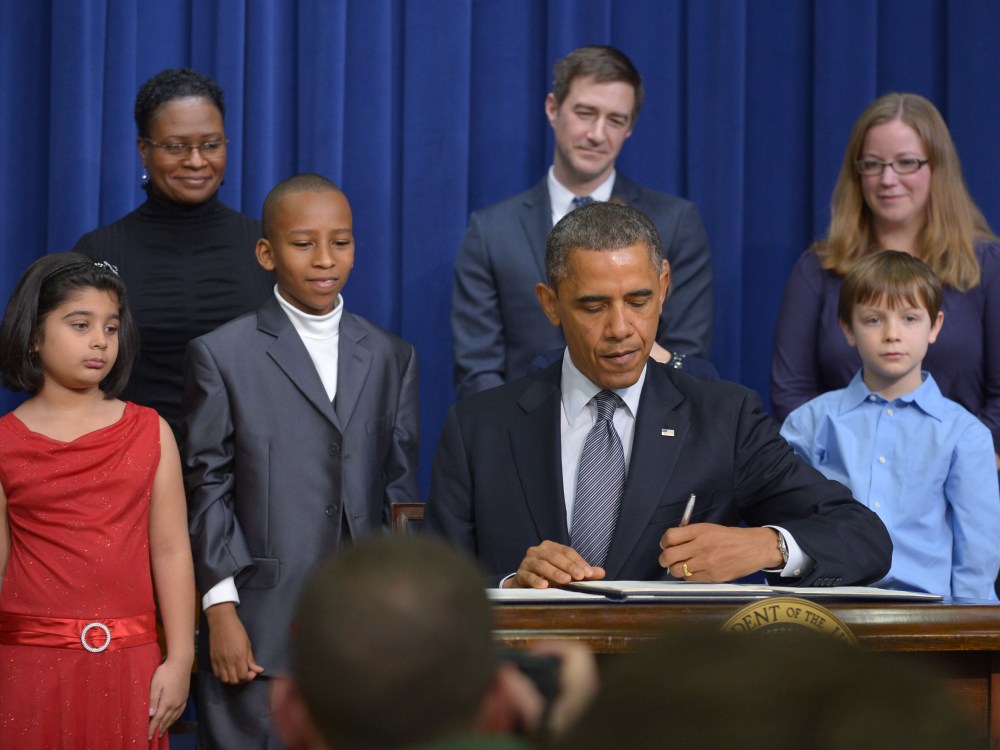 As guests look on, President Barack Obama signs executive actions to curb gun violence at the South Court Auditorium of the Eisenhower Executive Office Building, next to the White House in Washington on January 16, 2013. (Photo by Mandel Ngan/AFP/Getty...