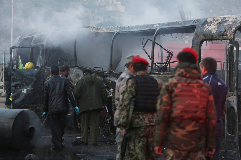 Afghan security guards inspect a damaged bus at the site of a suicide attack by the Taliban in Kabul, Afghanistan on Dec. 13, 2014. (Rahmat Gul/AP)