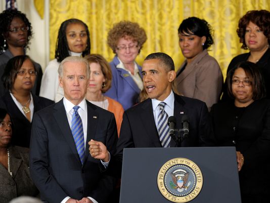 President Barack Obama  speaks while flanked Vice President Joe Biden  and relatives of gun violence victims, in the East Room at the White House, on March 28, 2013. President Obama urged Congress to pass measures such as background checks to protect...