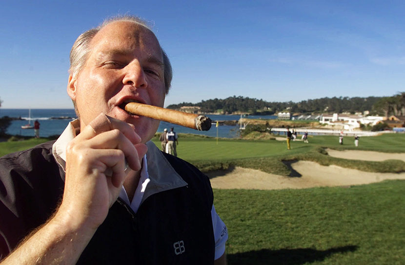 In this 2001 file photo, Talk show host Rush Limbaugh puffs on his Ashton VSG cigar while waiting to tee off at the Pebble Beach Golf Links during the AT&T Pebble Beach National Pro-Am in Pebble Beach, Calif. (Photo by Eric Risberg/AP)