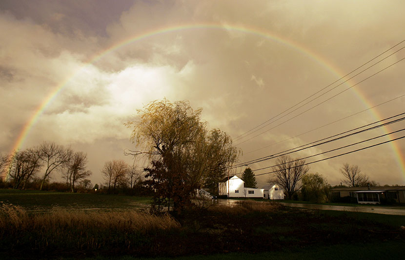 A rainbow is seen arching over a farm house in Dover, Pa. (Photo by Carolyn Kaster/AP)