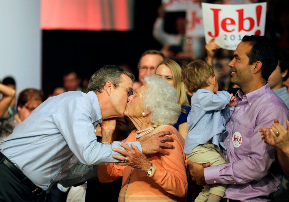 Former Florida Gov. Jeb Bush, left, kisses his mother Barbara as his son George, right, watches as he takes the stage to formally join the race for president with a speech at Miami Dade College, June 15, 2015, in Miami. (Photo by David Goldman/AP)